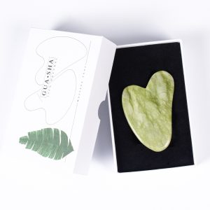 Green heart-shaped wholesale jade gua sha tool for B2B private label beauty brands.