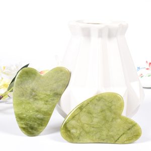 Green heart-shaped wholesale jade gua sha tool for B2B private label beauty brands.
